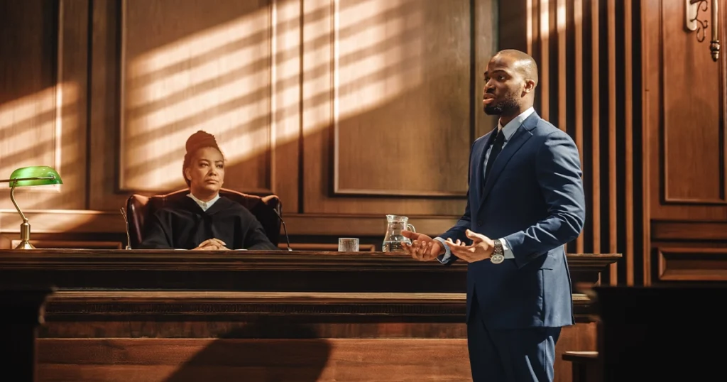 A prosecutor speaking in a courtroom before a judge during a case.
