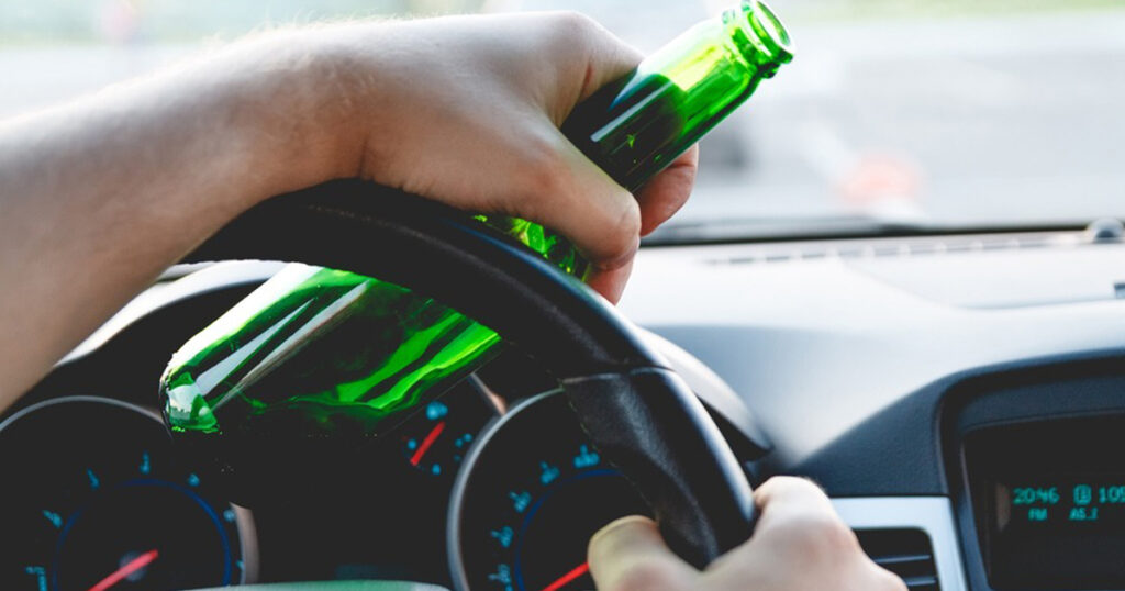 Driving with alcohol bottle in hand