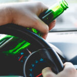 Driving with alcohol bottle in hand