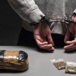 Handcuffed suspect with seized drug evidence