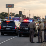 Texas police officers standing near patrol SUVs at a DUI checkpoint on a highway.