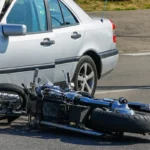 Motorcycle lying on its side after colliding with a car
